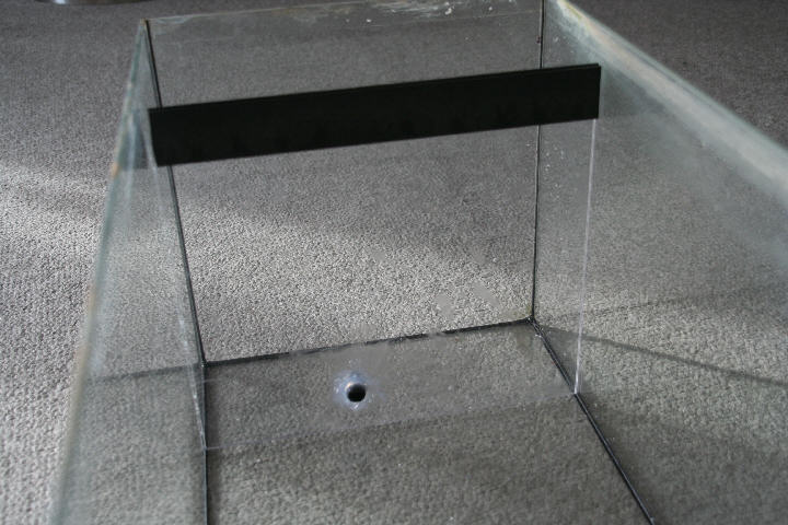 Du starter med at skære et plexiglas til så det passer som på billedet. Det skal ikke gå helt op til kanten af akvariet (billedet)